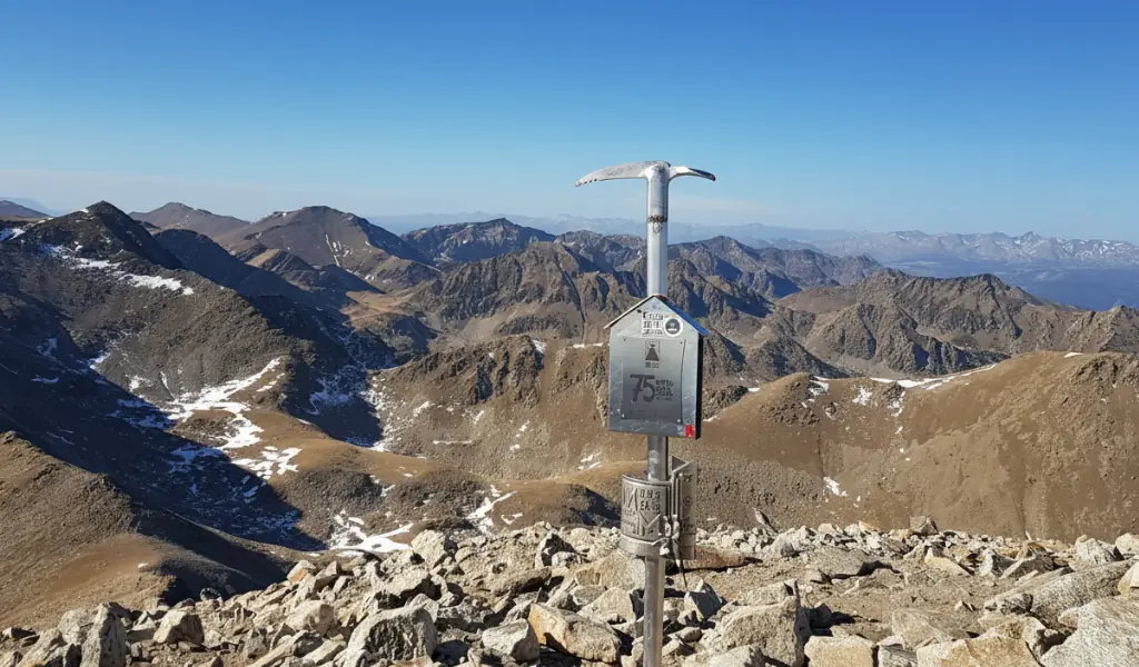Excursionistas en la cima del Pic de Bastiments con panorámicas del Pirineo