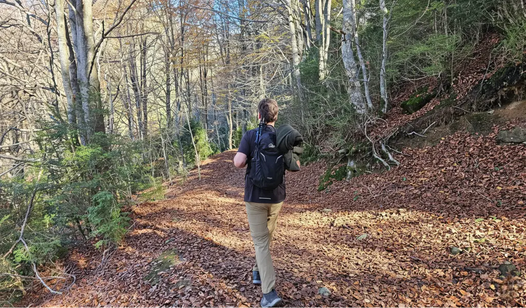 Tramos sencillos: bastones plegados y listos para el siguiente cambio de terreno caminata en terreno llano con bastones plegados en la mochila